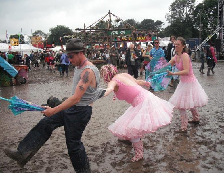 Festival-goers in deep mud at an outdoor music festival